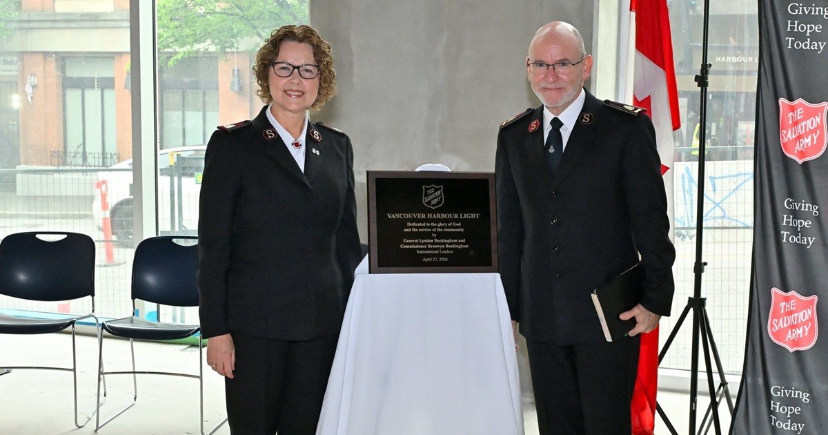 A woman and a man stand next to a plaque